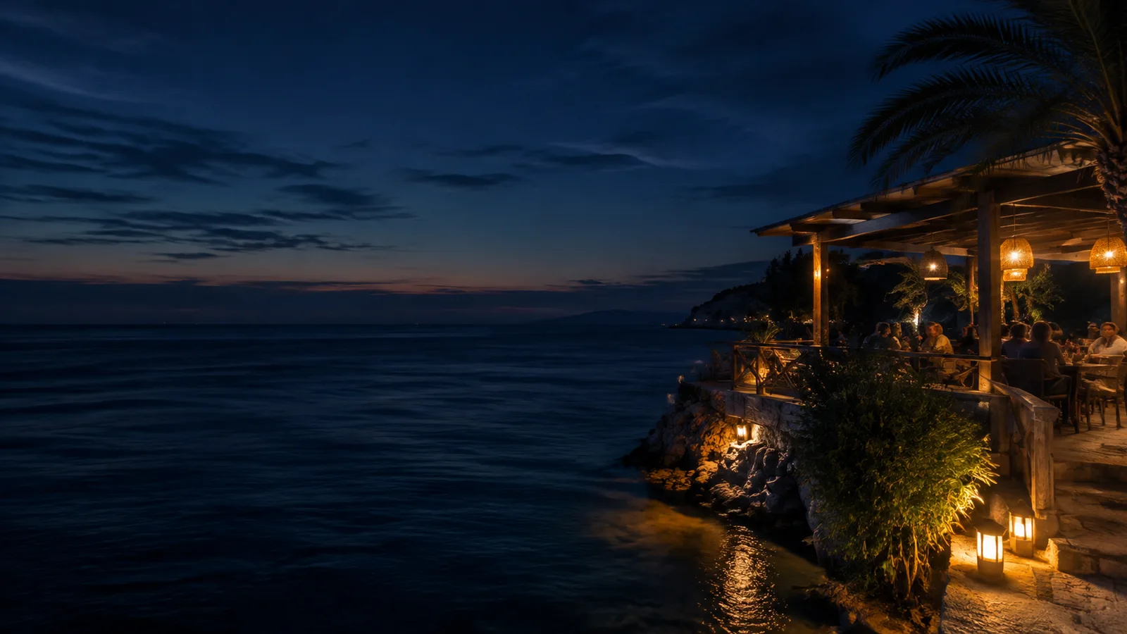 A softly lit coastal terrace at night